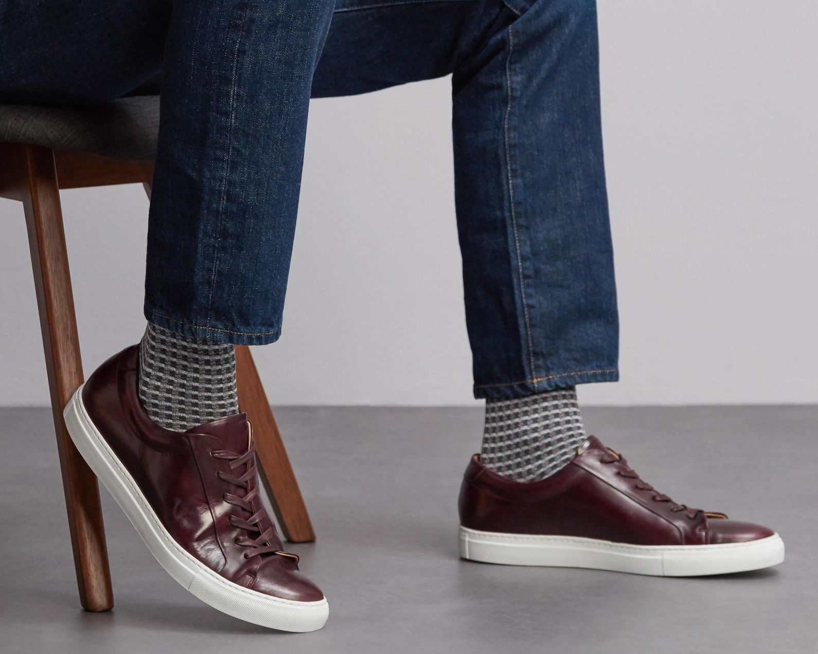 man sitting wearing grey LSC socks with brown leather trainers