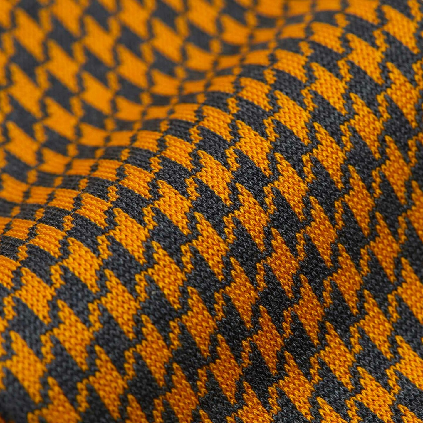 A close up of a orange and black patterned sock