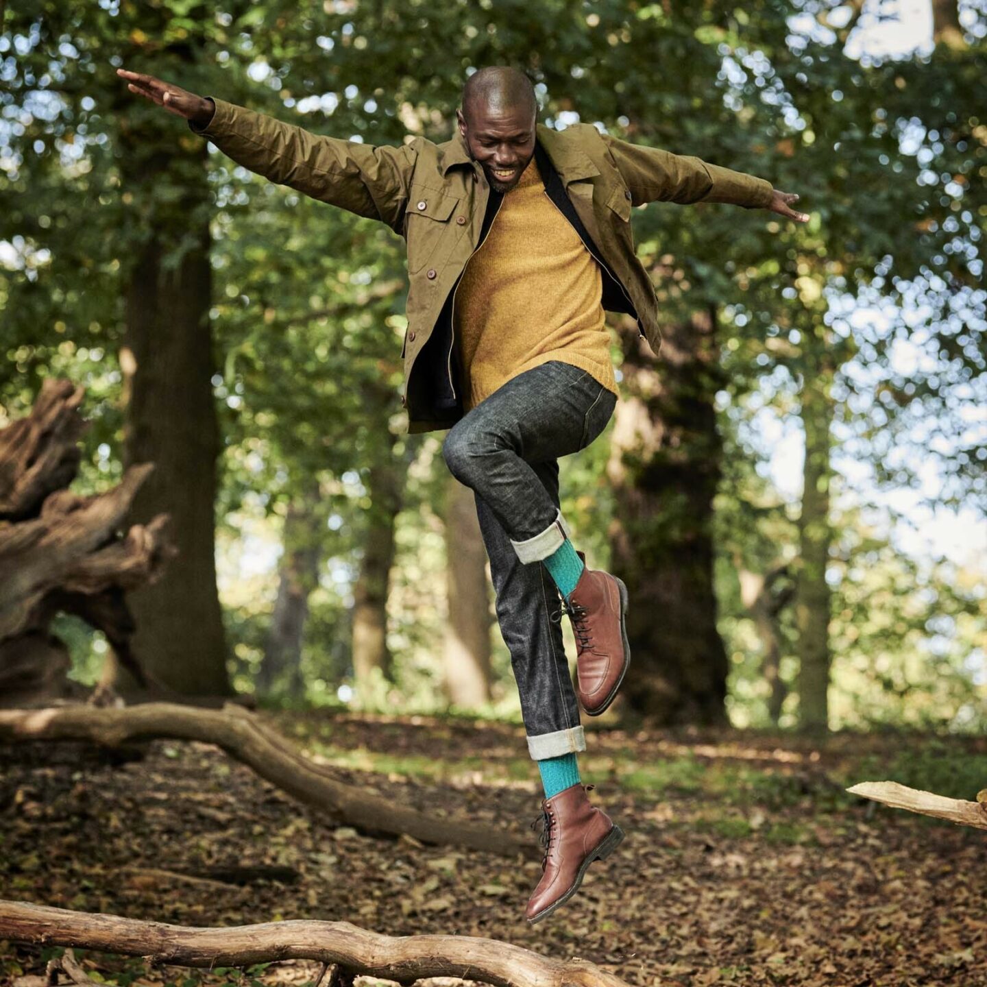 Ben Harris leaping in forest and wearing turquoise boot socks