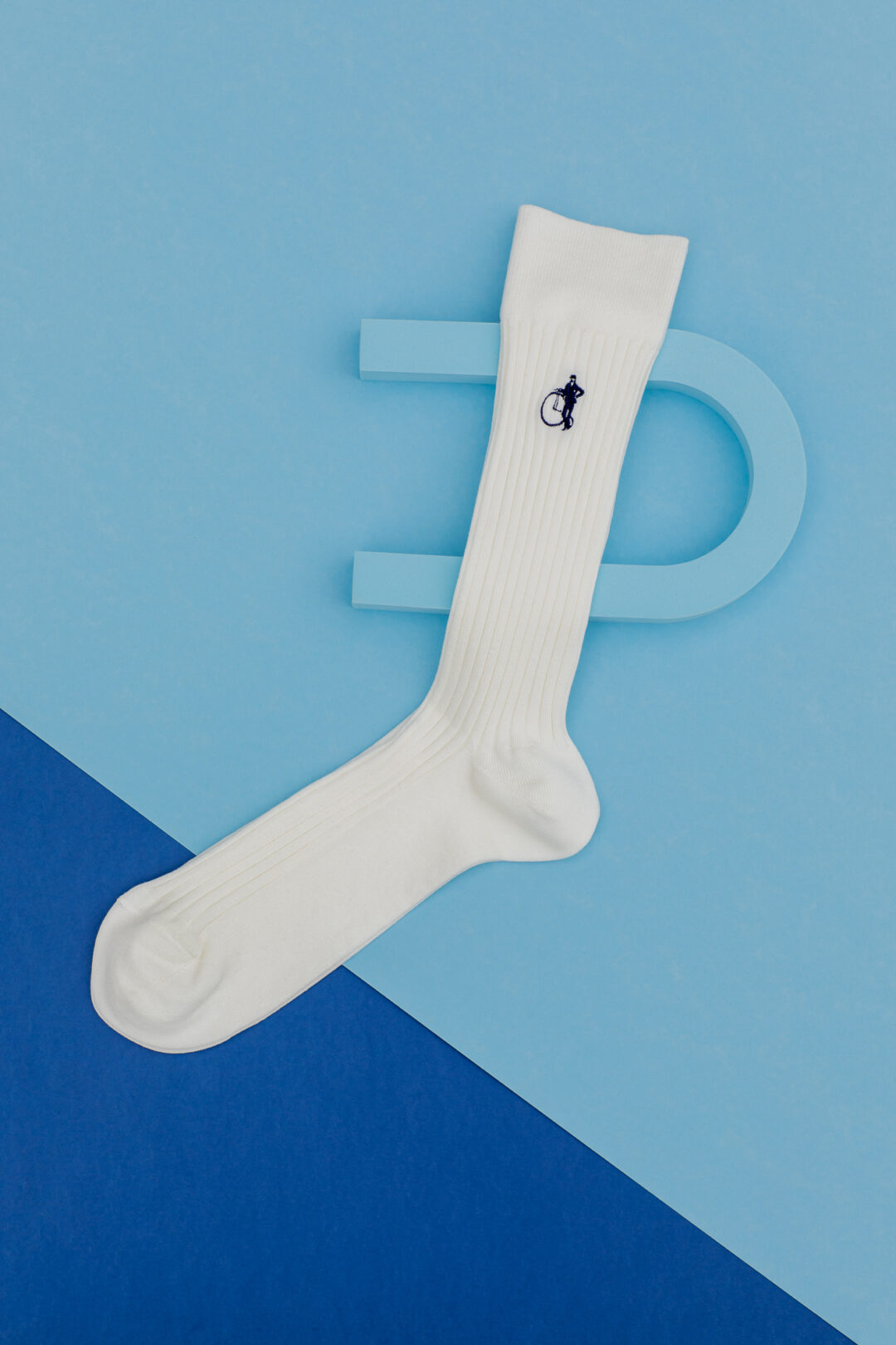 Mens plain white socks on a split light and dark blue background